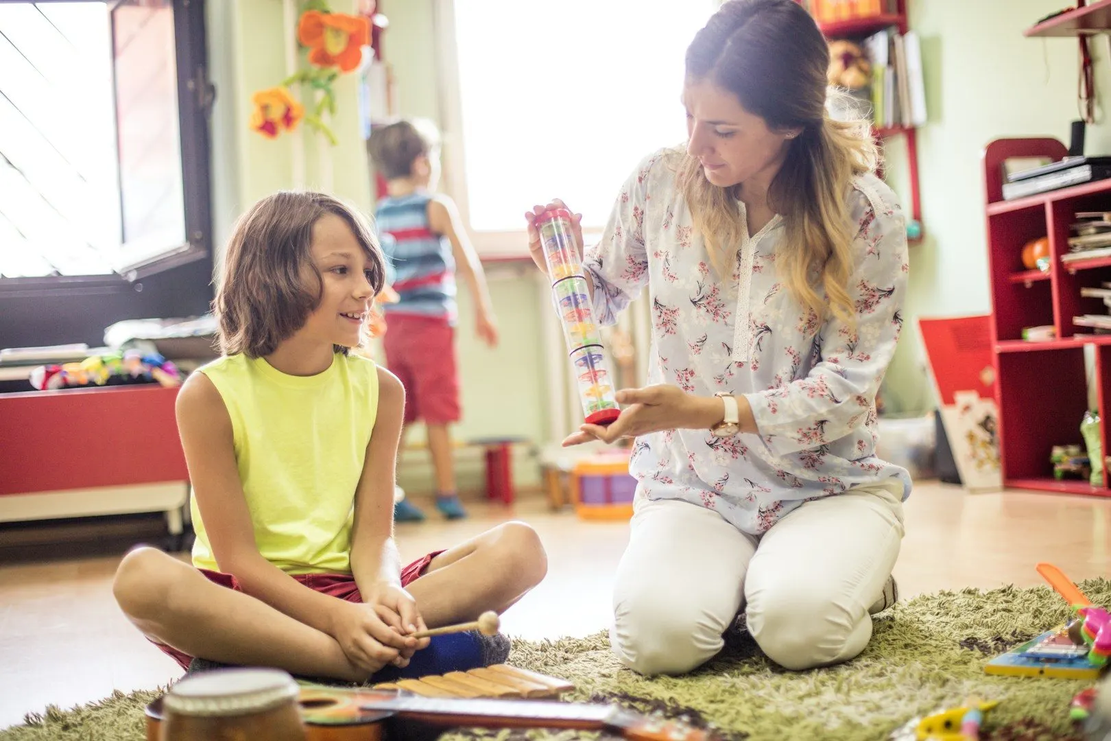 Eine Pädagogin zeigt einem Kind ein Montessori-Material im Klassenzimmer